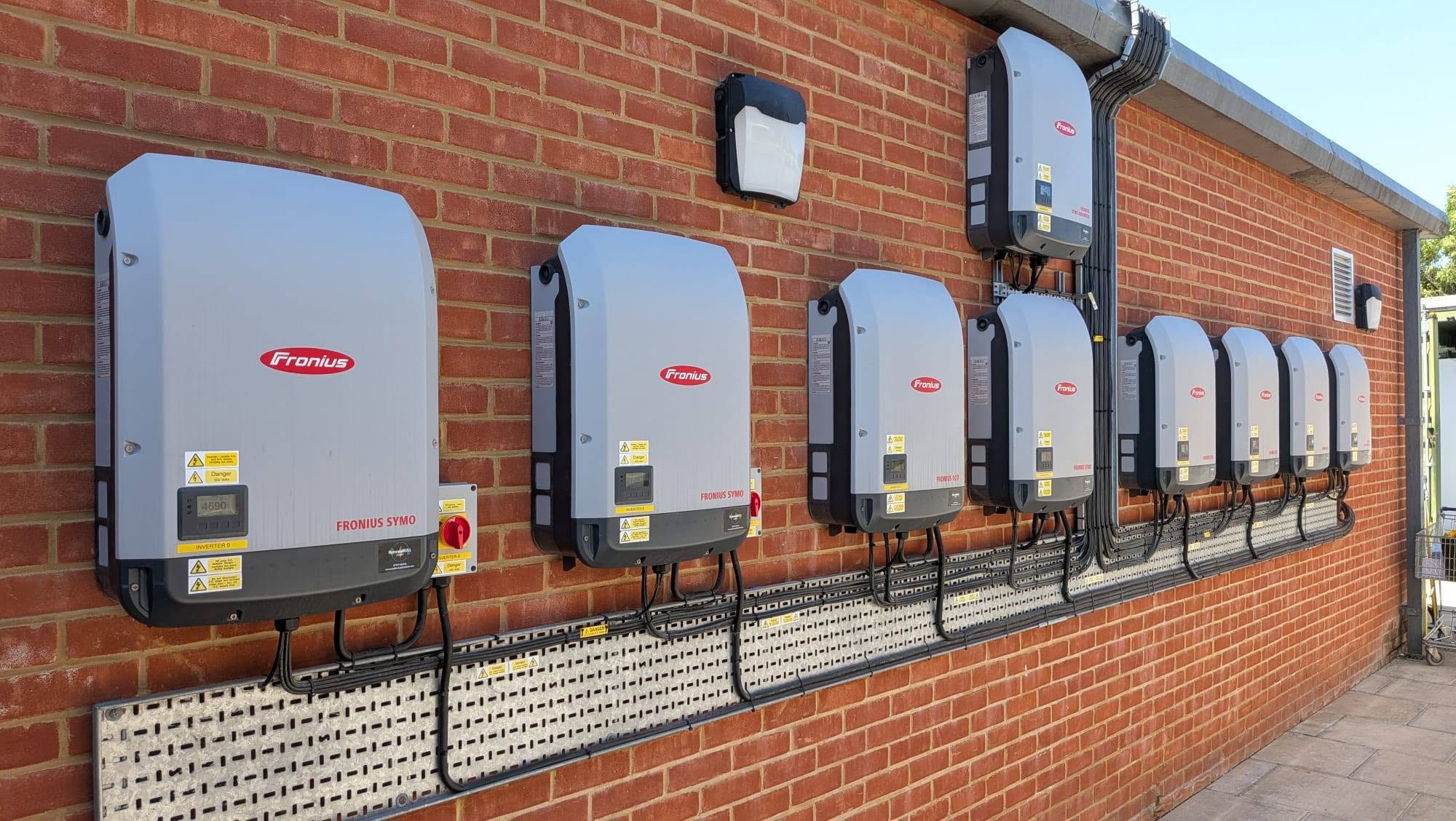 Fronius inverters installed on the exterior wall of a commercial building.