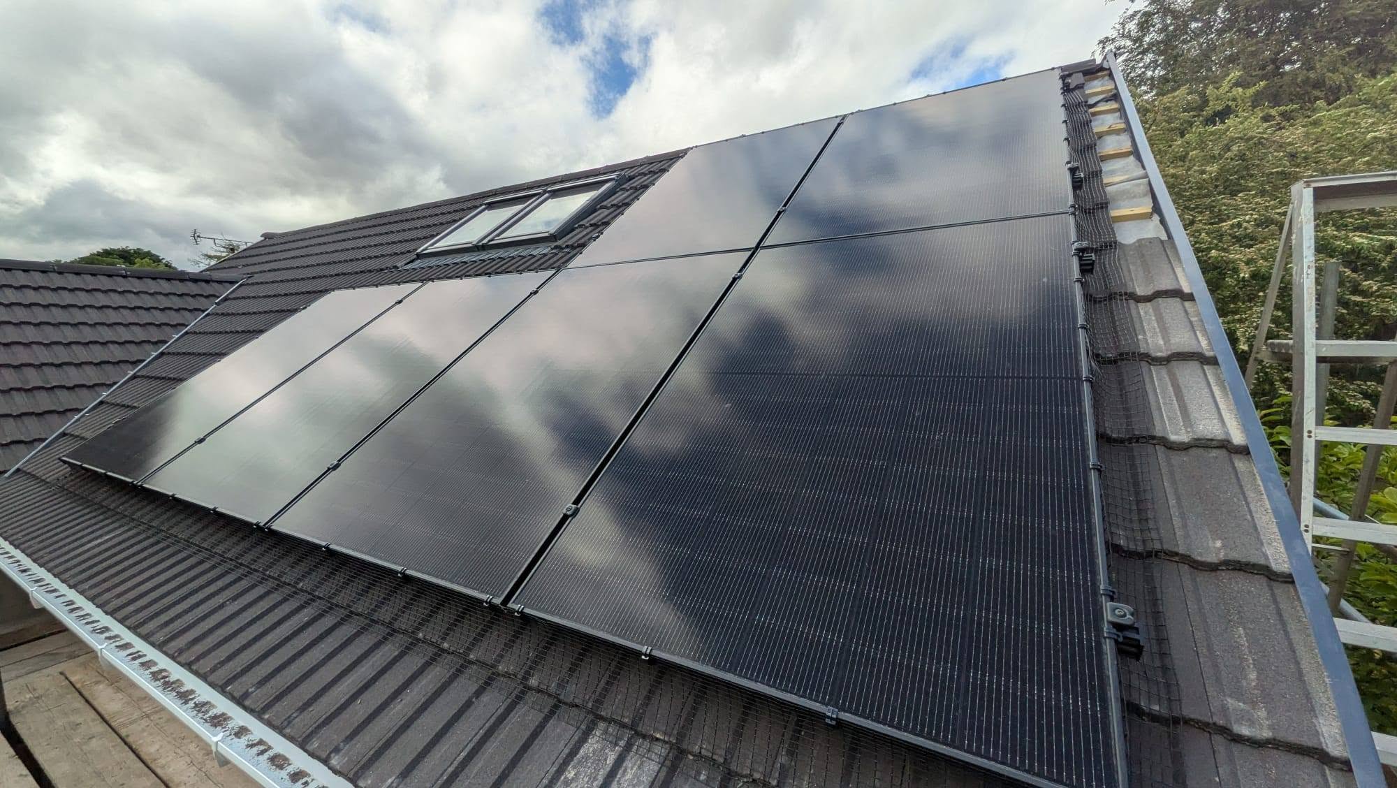 Two dark solar panels fitted to a tiled residential roof.